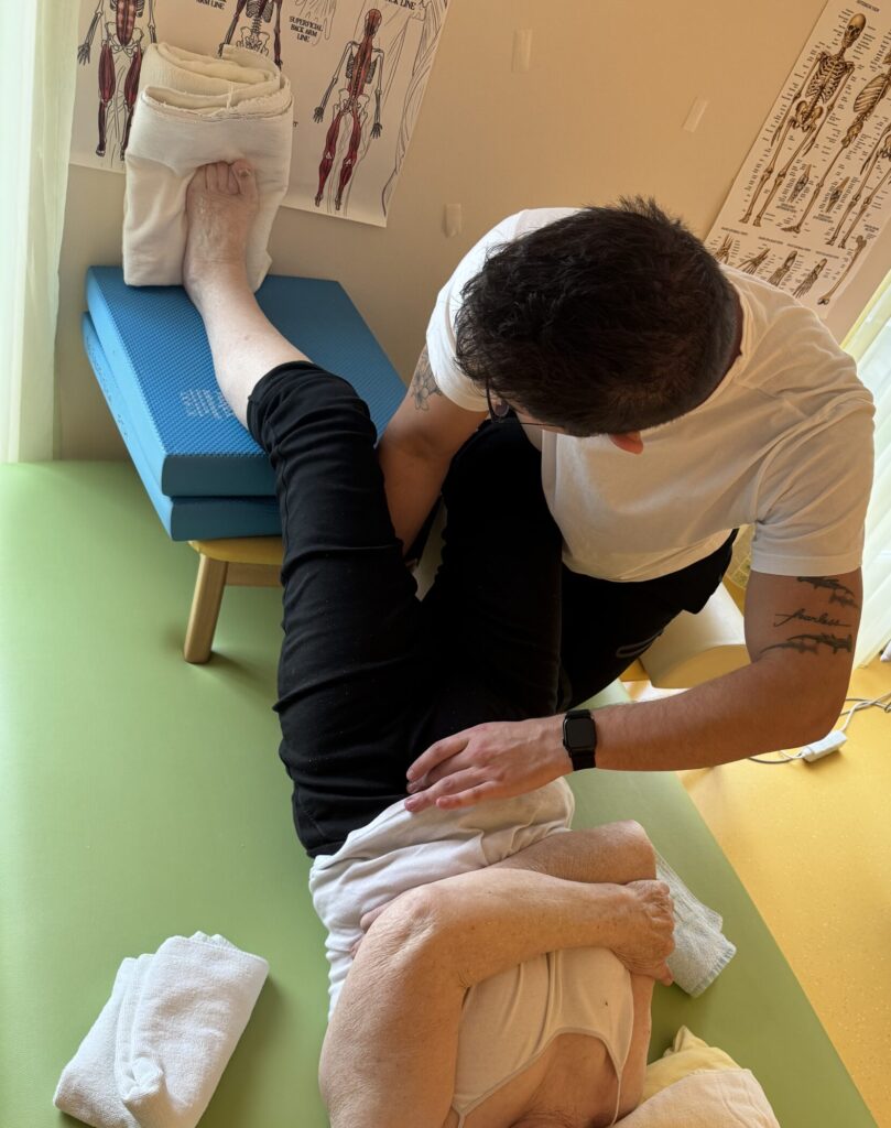Fizioterapevt izvaja nevrofizioterapijo na pacientu v Novi Gorici za rehabilitacijo po poškodbi.